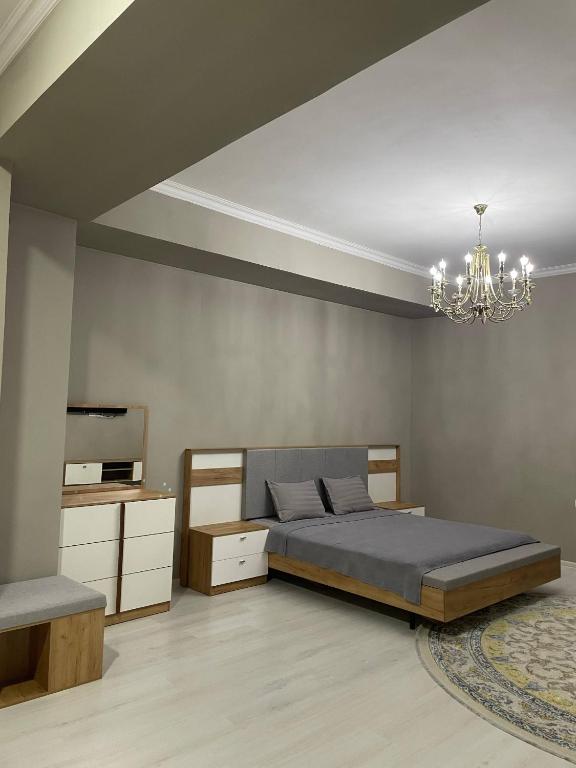 a bedroom with a bed and a chandelier at Парк апарт-отел in Namangan