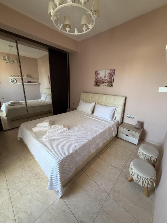 a bedroom with a large white bed and a chandelier at Kali's home in Komotini