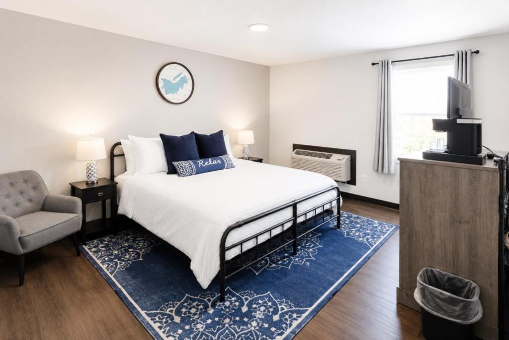 a bedroom with a bed and a chair and a television at Private King Studio Close To The Action in Muskegon