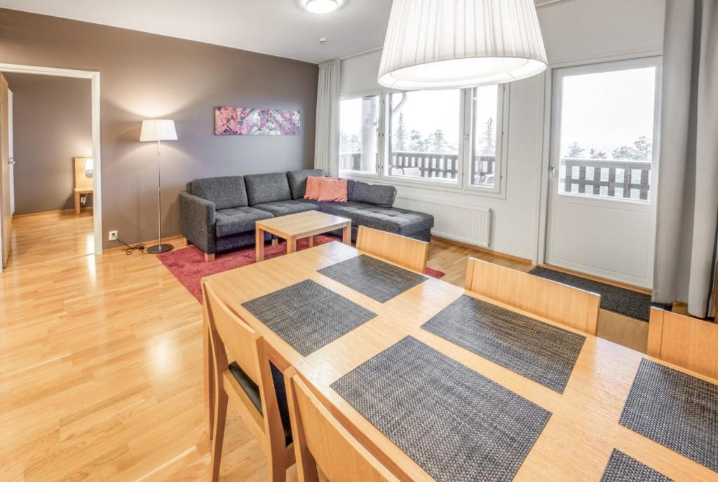a living room with a table and a couch at Ruka Ski Chalets in Ruka