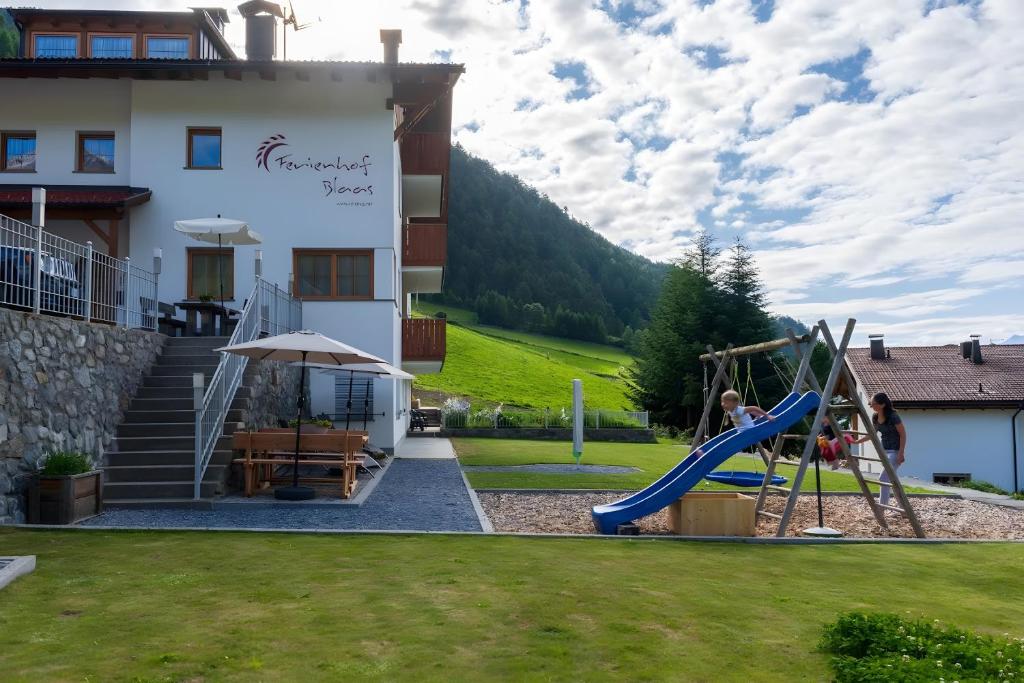 a playground in front of a house with a slide at Ferienhof Blaas in Malles Venosta