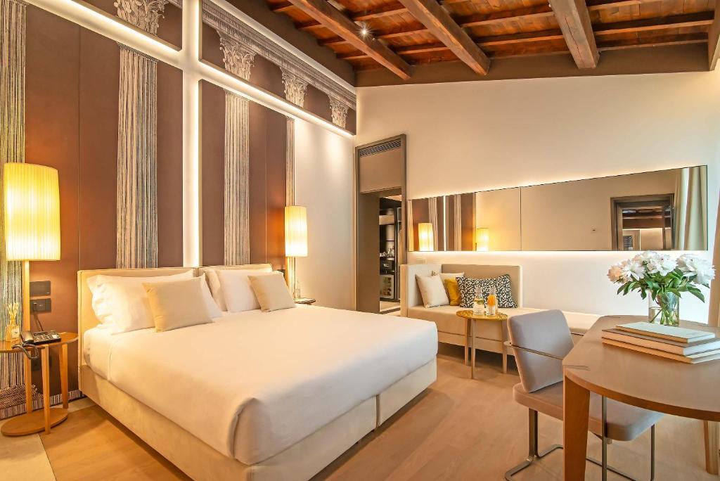 a bedroom with a large white bed and a desk at Domus Teatro di Pompeo in Rome
