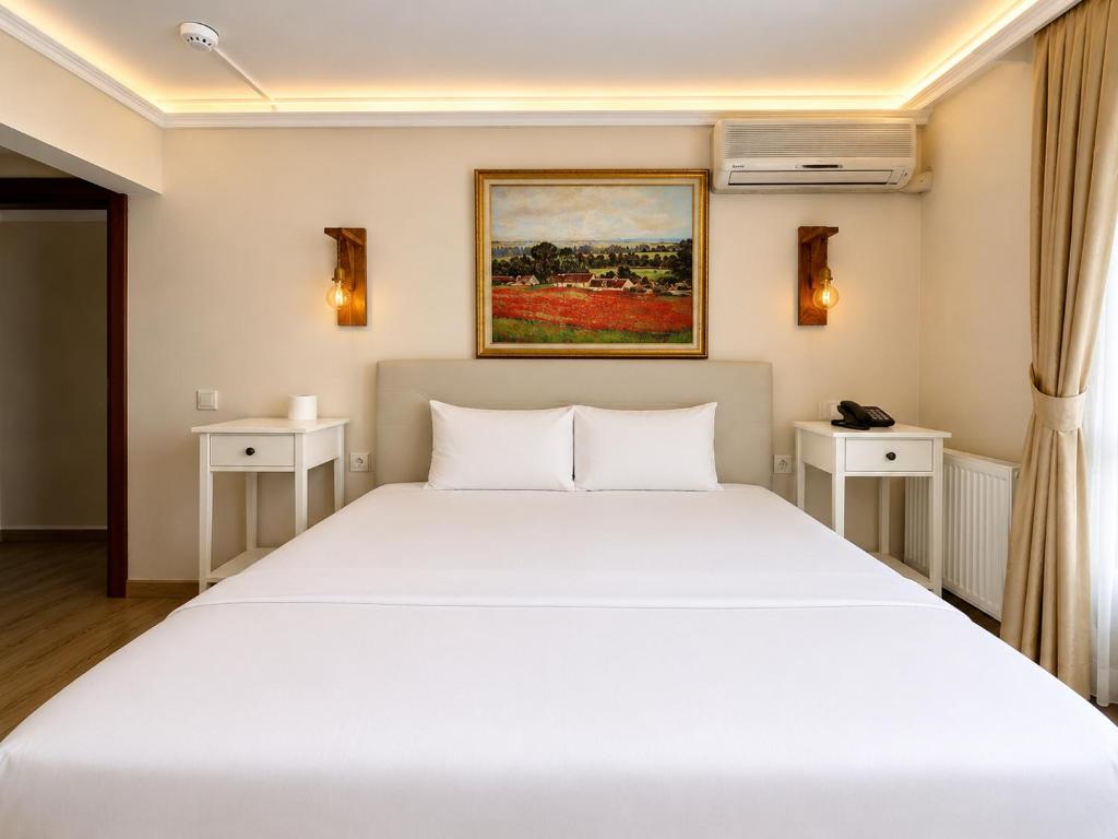 a bedroom with a large white bed with two night stands at Motto Polonezköy in Beykoz
