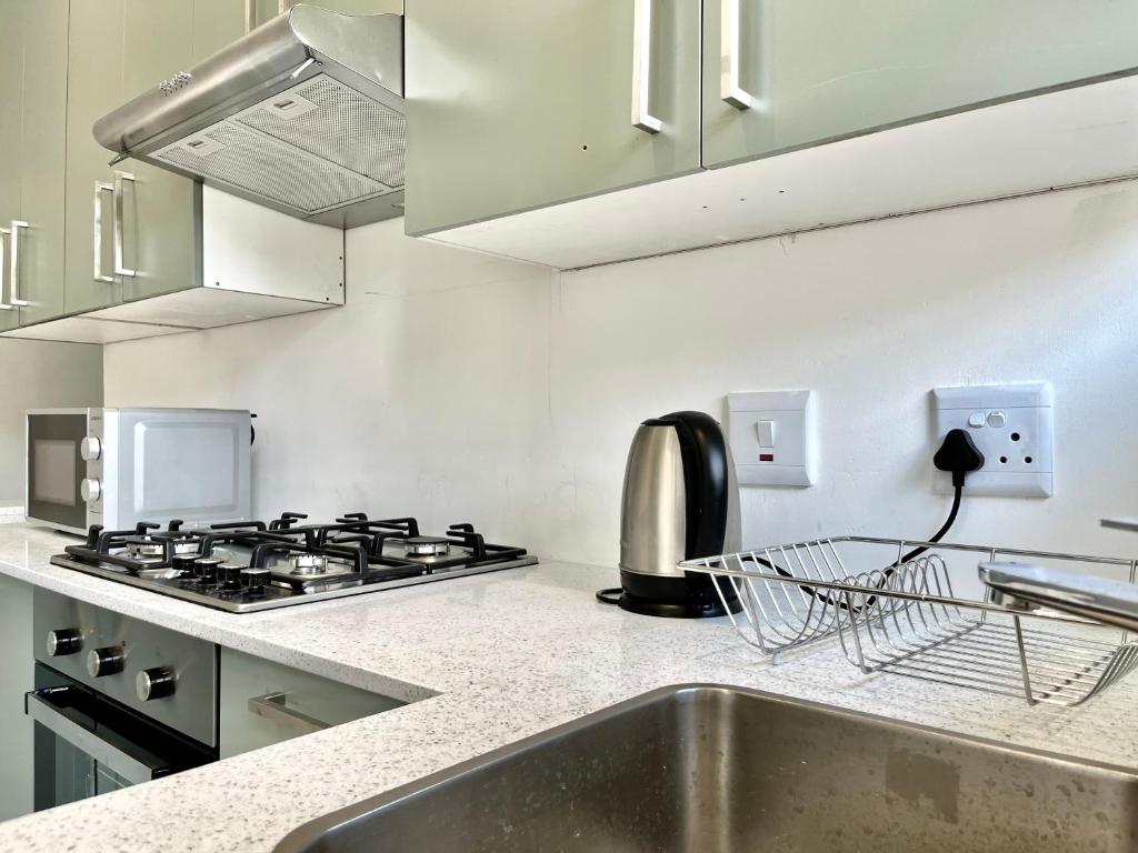 a kitchen with a stove and a sink at Number 15 Jadde Apartments in Sandton