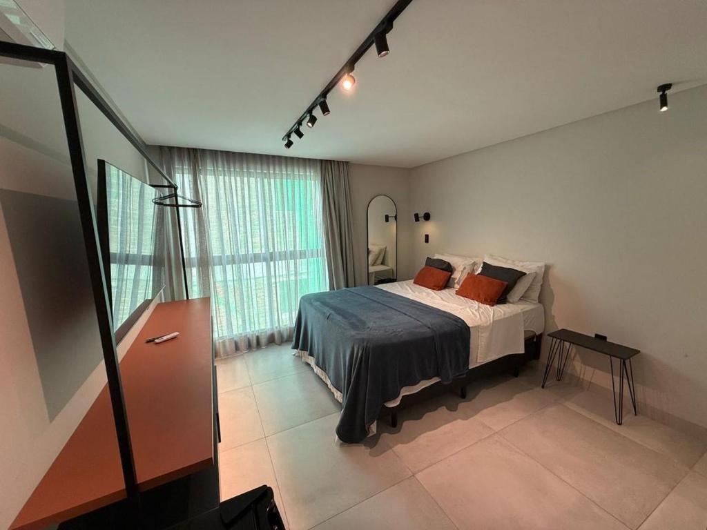 a bedroom with a bed and a large window at Flat Praiano Intermares Boutique in Cabedelo