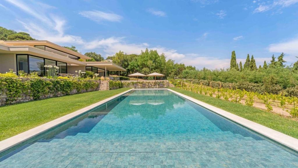 a swimming pool in the backyard of a house at Villa Trois-Pins in Ramatuelle