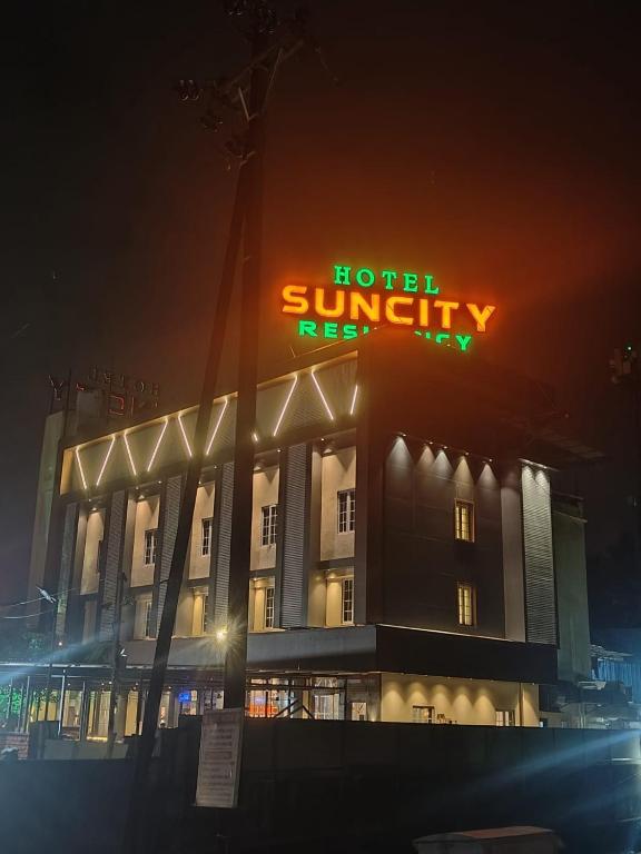 a hotel with a sign on top of it at night at Hotel Suncity Residency in Kālundri