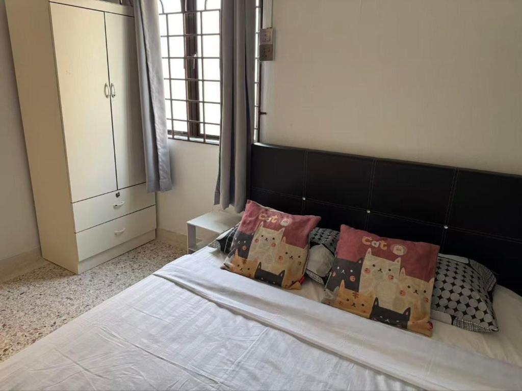 a bedroom with a bed with pillows on it at 8minit walk to jongke in Malacca
