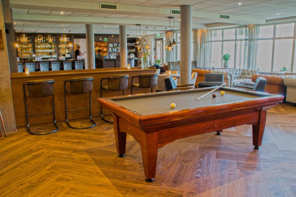 een pooltafel in een kamer met een bar bij Landgoed Hotel Tatenhove Texel in De Koog