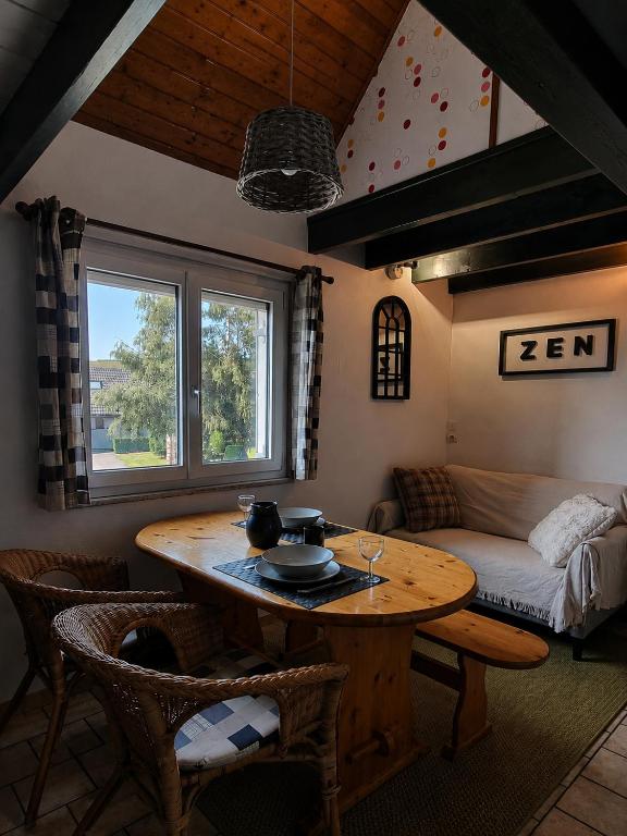 a living room with a table and a couch at Duplex le Randonneur - Les Apparts du Sancy in Chastreix