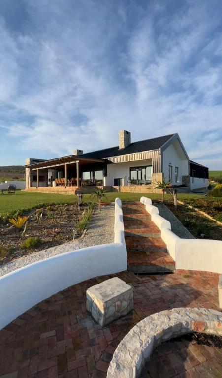 a house with a brick walkway in front of a building at Farmstead at ECS winery in Lake Marina
