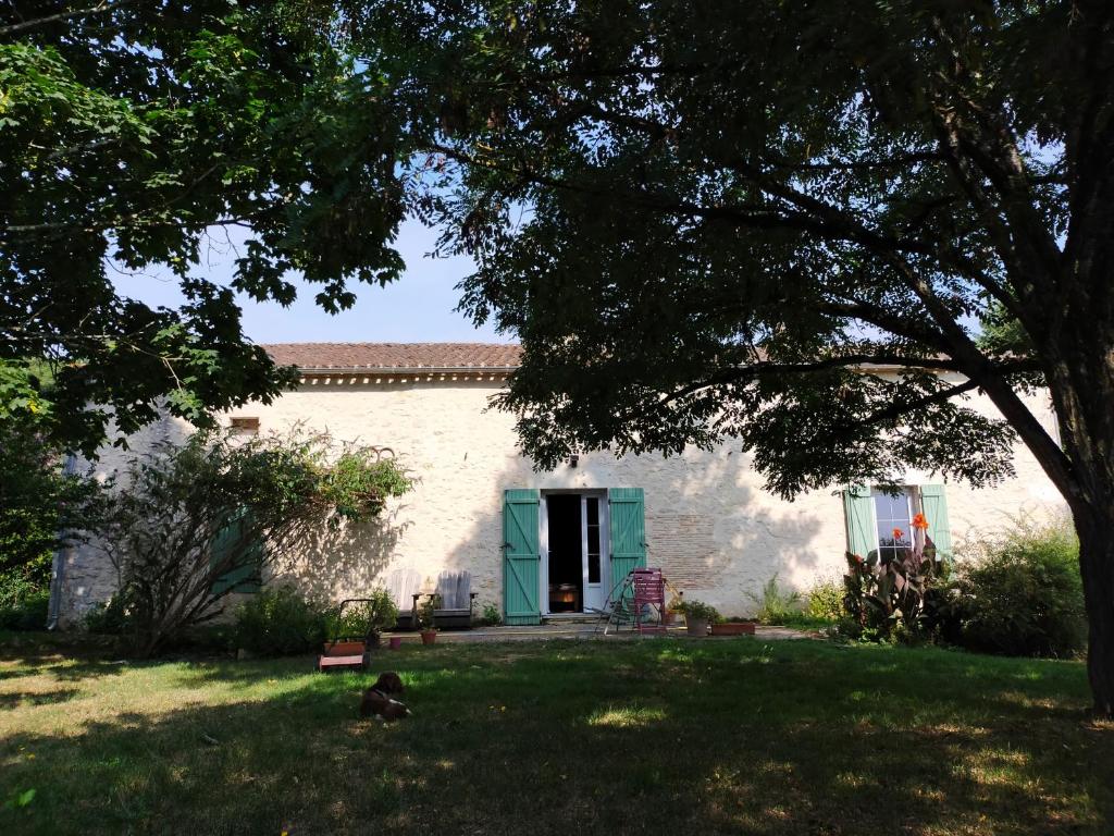 a house with a green door and a yard at Les 3 Vignobles in Pardaillan