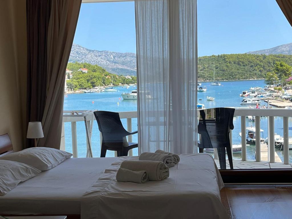 a bedroom with a bed and a view of a harbor at nb APARTMENTS by the sea in Lumbarda