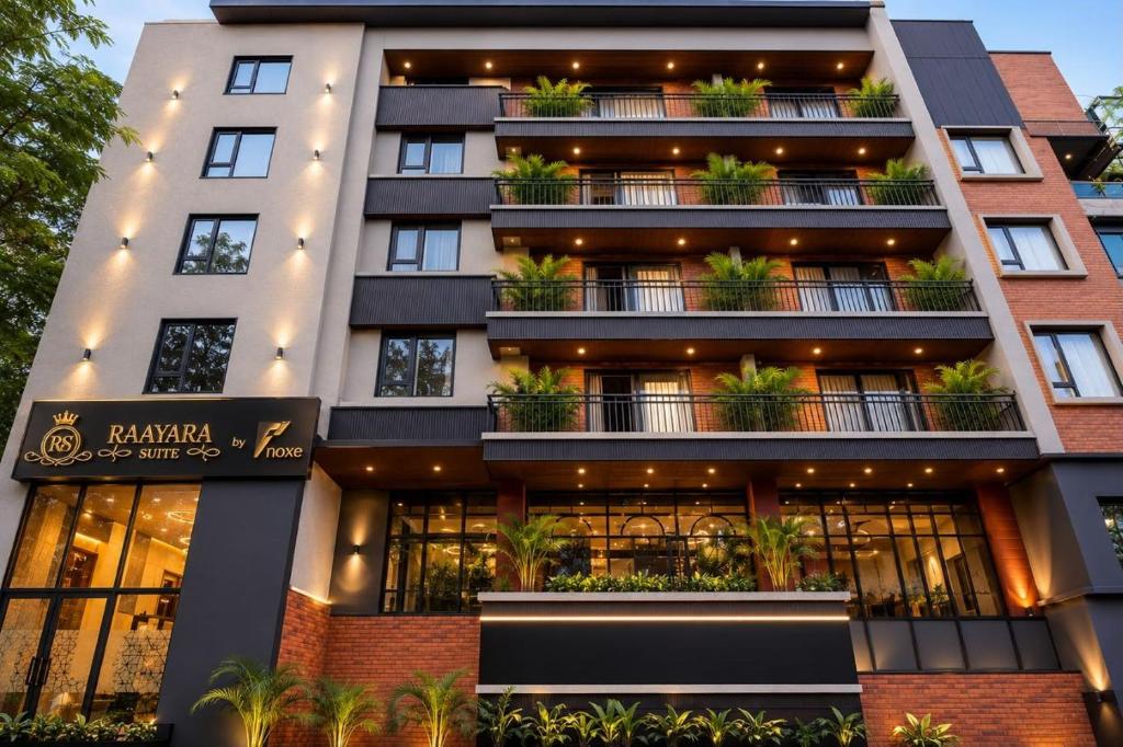 a large building with potted plants on the balconies at Raayara Suites in Bangalore