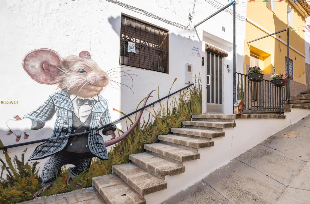 a mural of a mouse in a suit on a wall at Casa Ratón Pérez in Navarrés