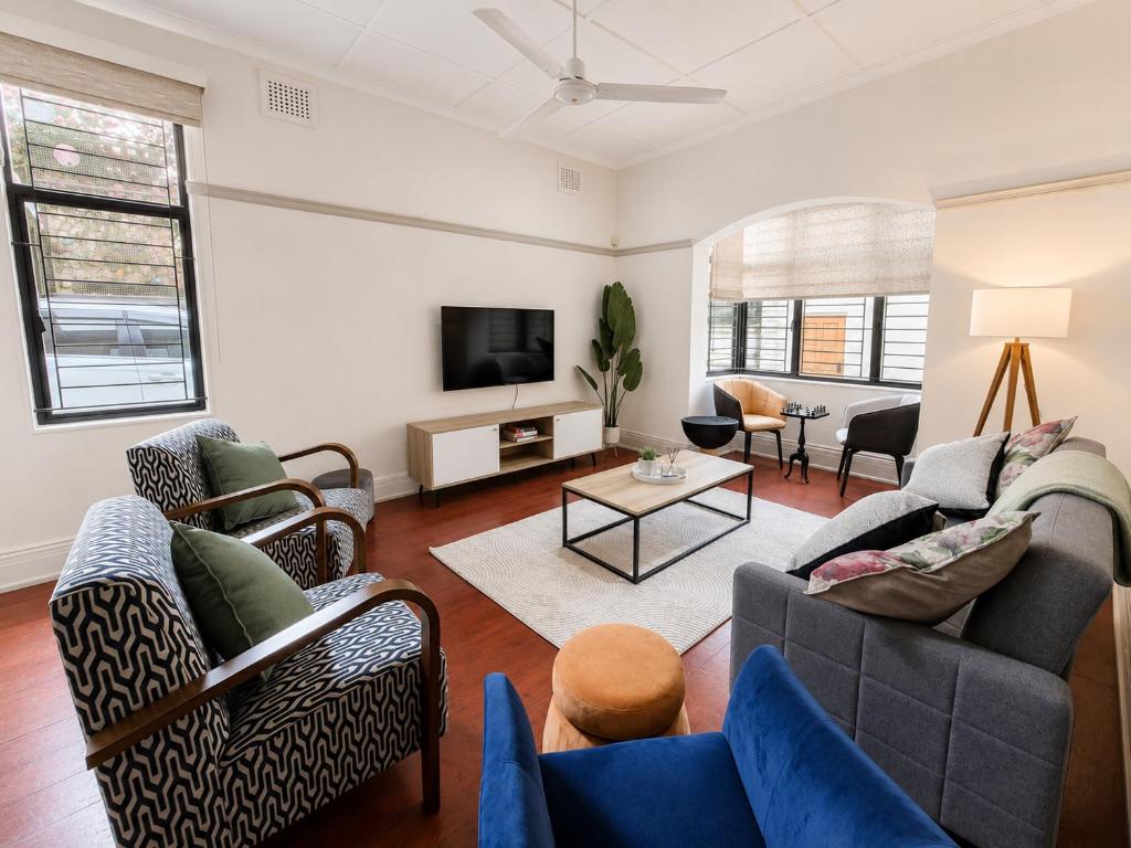 a living room with two couches and a tv at Musgrave Escape - 3 bedroom home with tennis court in Durban