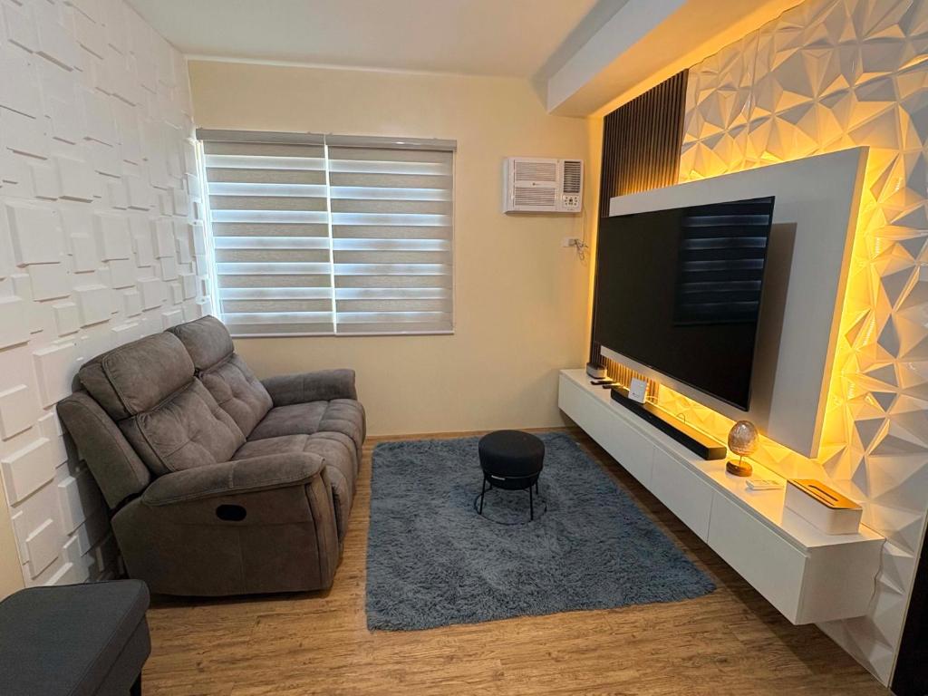 a living room with a couch and a flat screen tv at Penthouse Nook - Ananda square in Manila