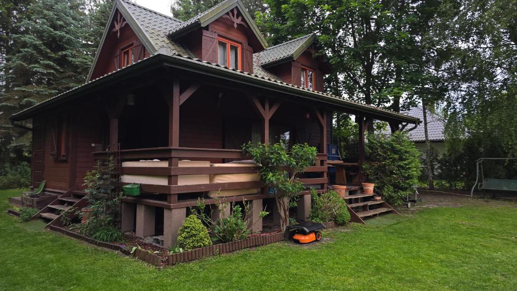 a large wooden house with stairs in a yard at Urokliwy domek Młynarze in Młynarze