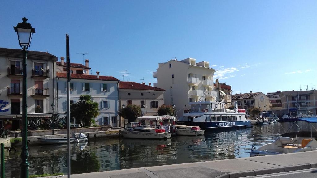 a group of boats docked in a canal with buildings at Riva San Vito 2 in Grado