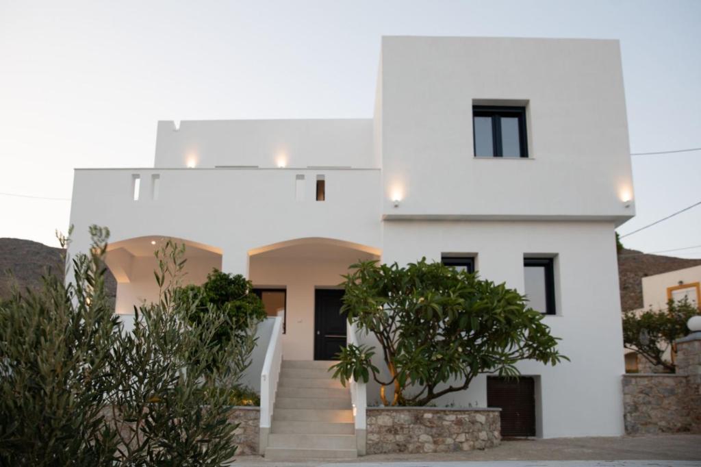 a white house with trees in front of it at Aellia Bay Residences in Alinda