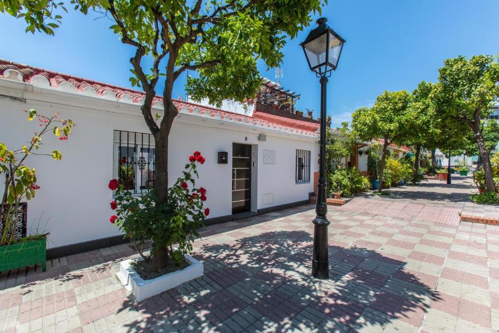 a street light next to a white building with a tree at Casa Alma Marbella in Marbella