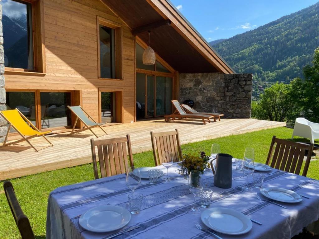 a table with plates on it in front of a house at LE REFUGE DE LUCE in Saint-Gervais-les-Bains