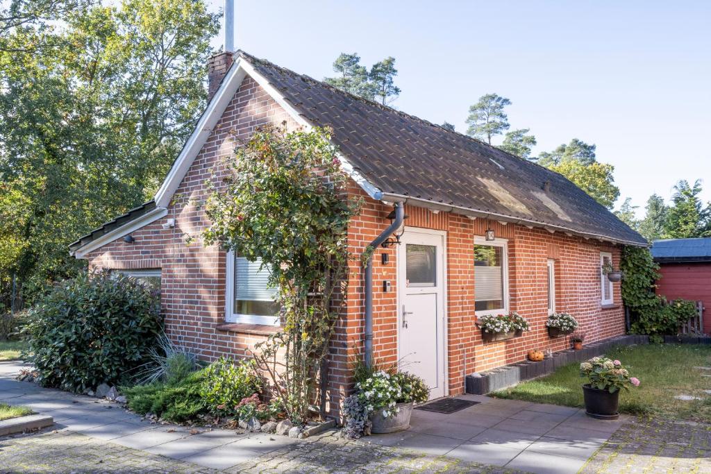 a small brick house with a white door at Ferienwohnungen Villa Lütt in Bleckede