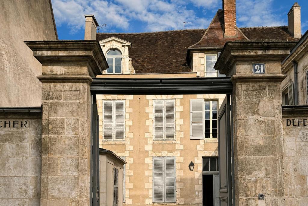 an old brick building with a sign on it at La Villa Du Temple - Climatisation in Auxerre