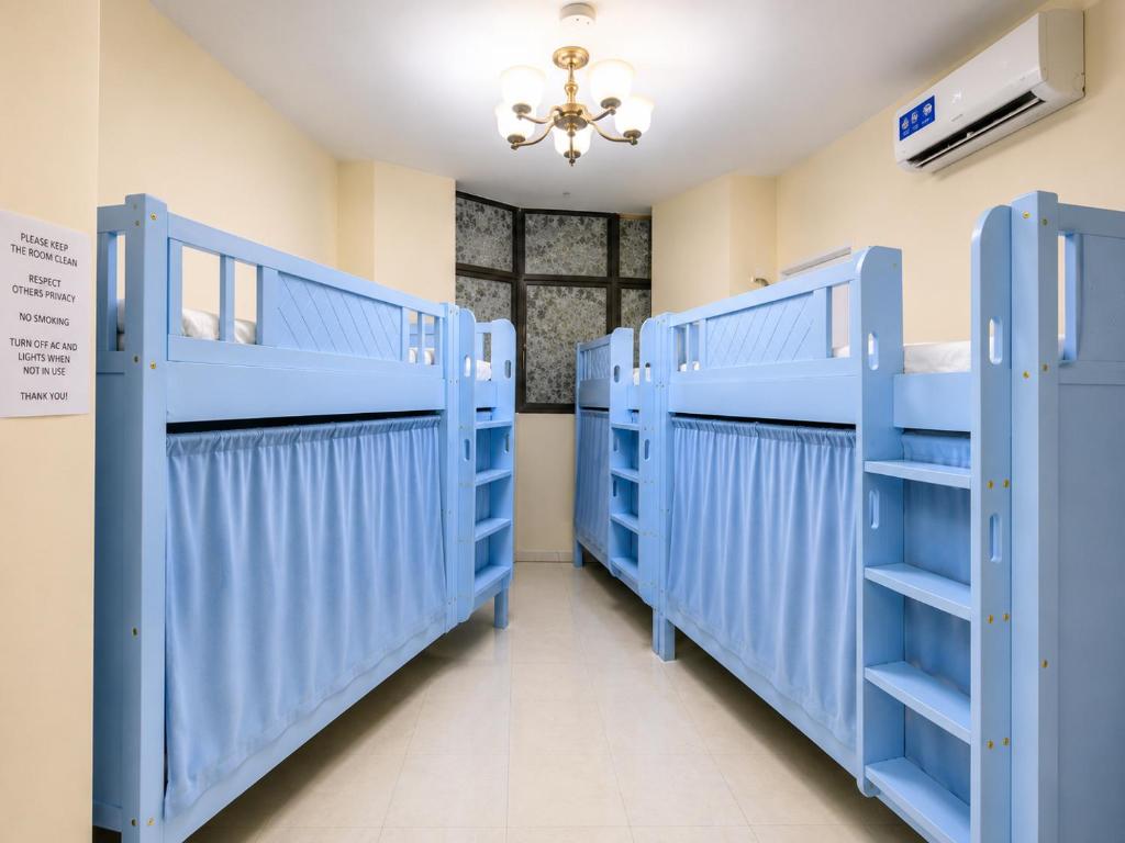 a row of blue bunk beds in a room at TIDY Premium Hostel, Sharjah in Sharjah