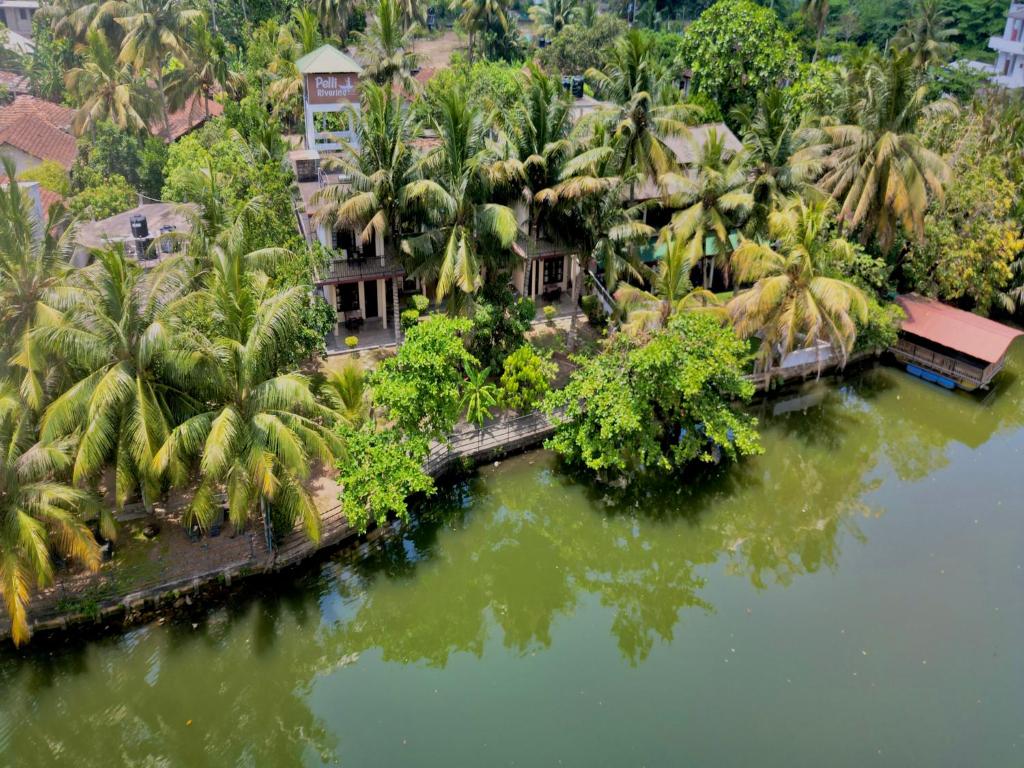 an aerial view of a resort with palm trees and water at Pelli Riverine in Weligama