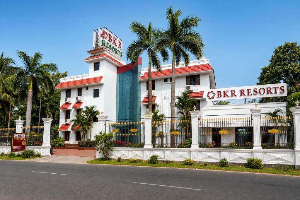 a white building with a sign for a casino at BKR Resort in Kuttālam