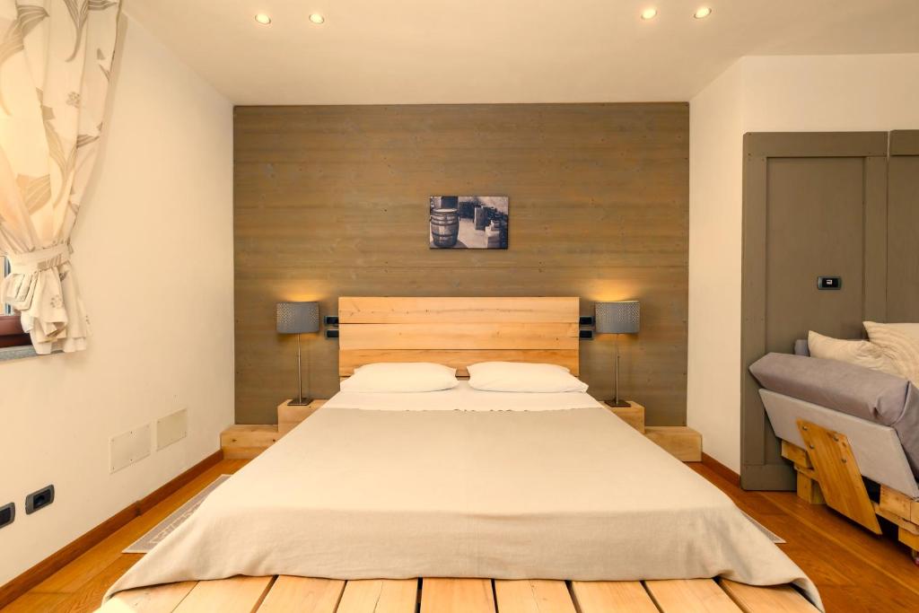a bedroom with a large bed with a wooden headboard at Ca'Luna Guest House in Mondovì