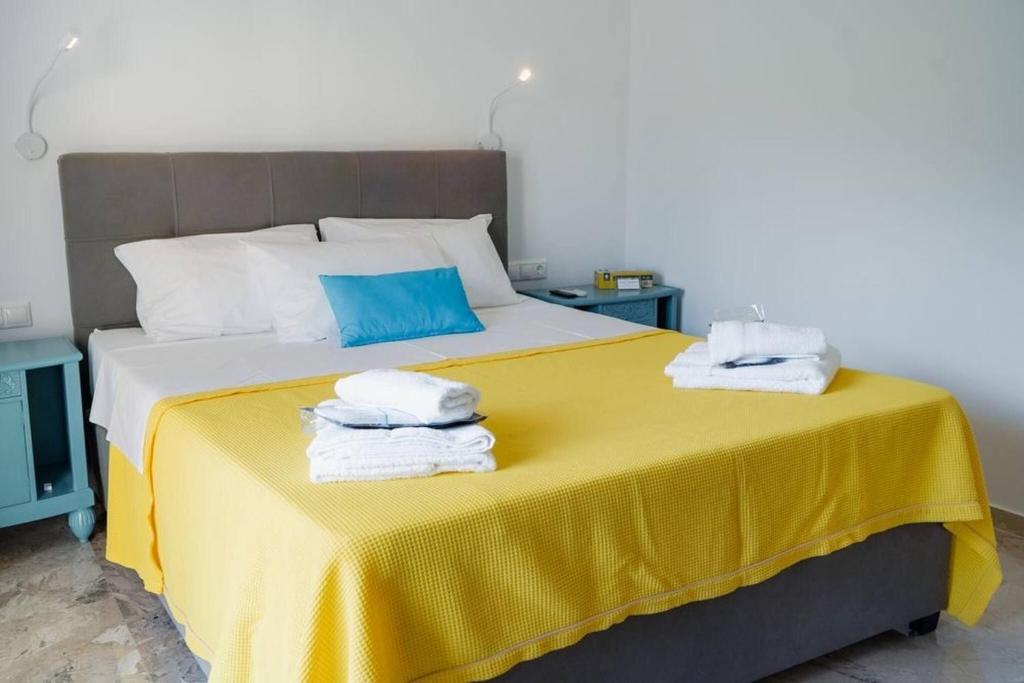 a bedroom with a yellow bed with towels on it at Vickys Apartment Diakopto in Diakopto