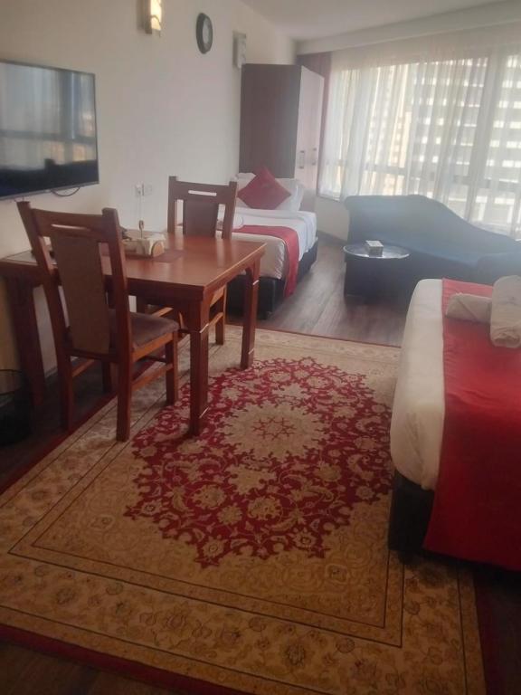 a hotel room with a table and a bed and a bedroom at Hidden Gem With Accomodation, Restaurant, Bar & Spa in Nairobi