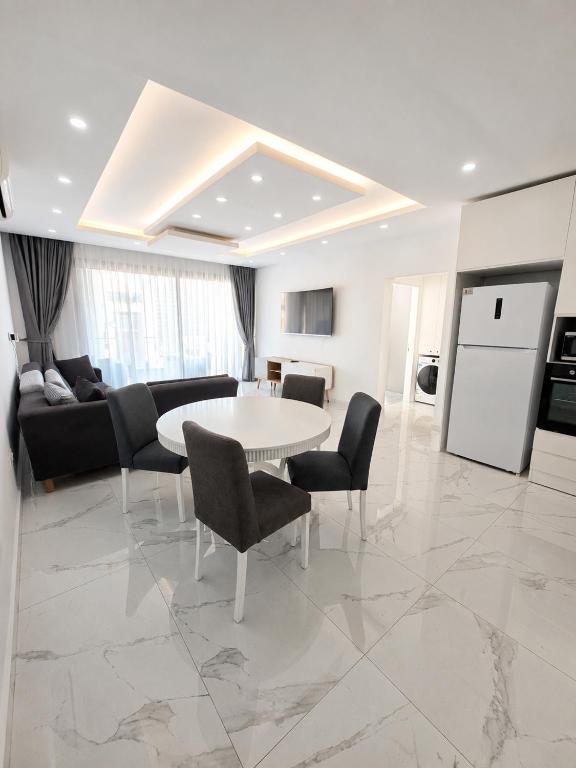 a white living room with a table and chairs at Blue life Long beach in Iskele