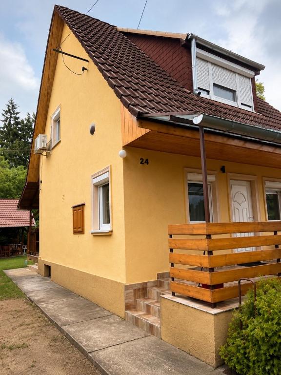 a yellow house with a brown roof at Pákász Nyaralóház in Tiszafüred