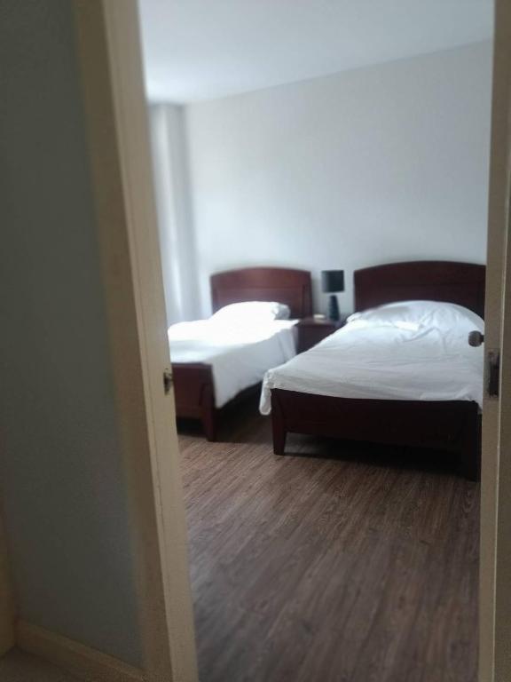a room with two beds and a hallway with two beds at Bonanza in Ban Khanong Phra Klang (1)
