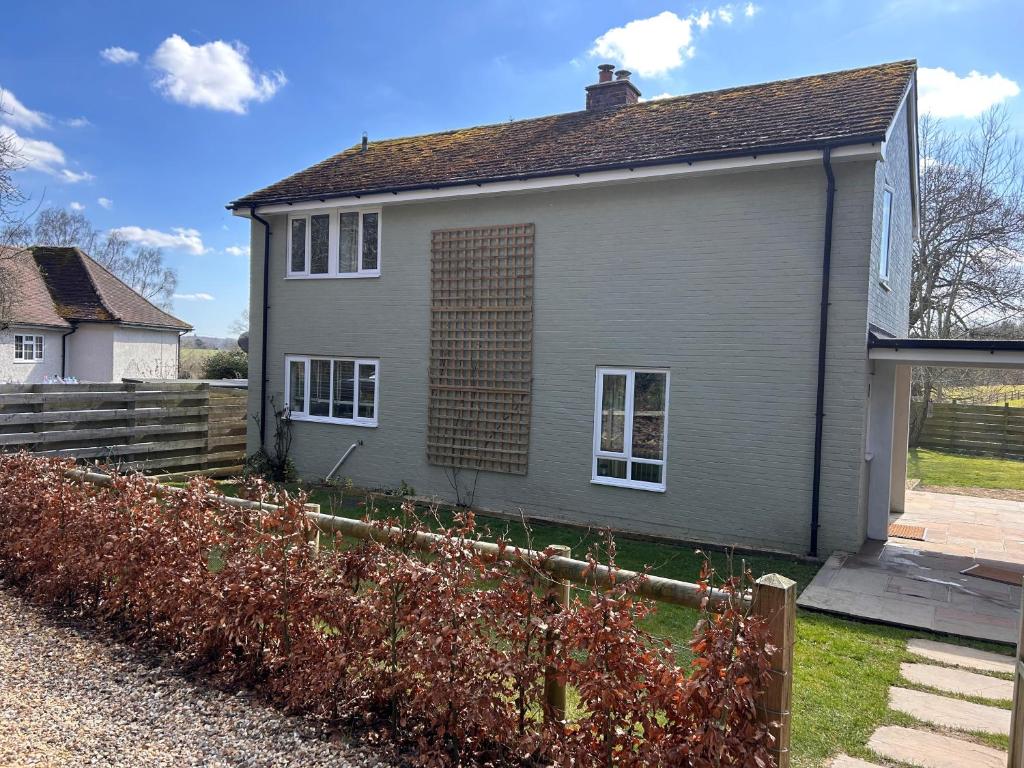 a gray house with a fence in front of it at Number 4 in Avington