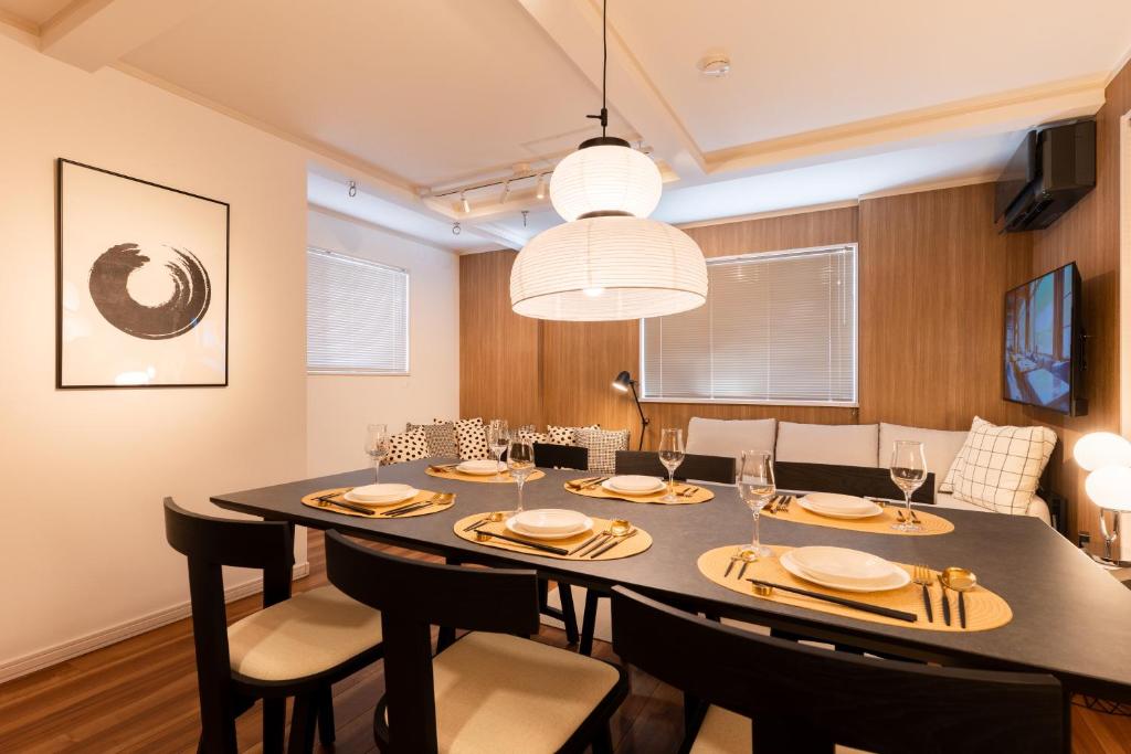 a dining room with a black table and chairs at The Ichikawa House in Ichikawa
