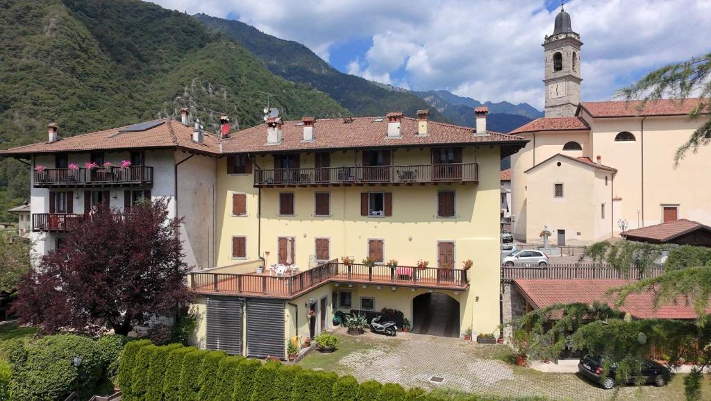 a large yellow building with a clock tower on a mountain at Casa Miravalle Mountain Apartments in Enguiso