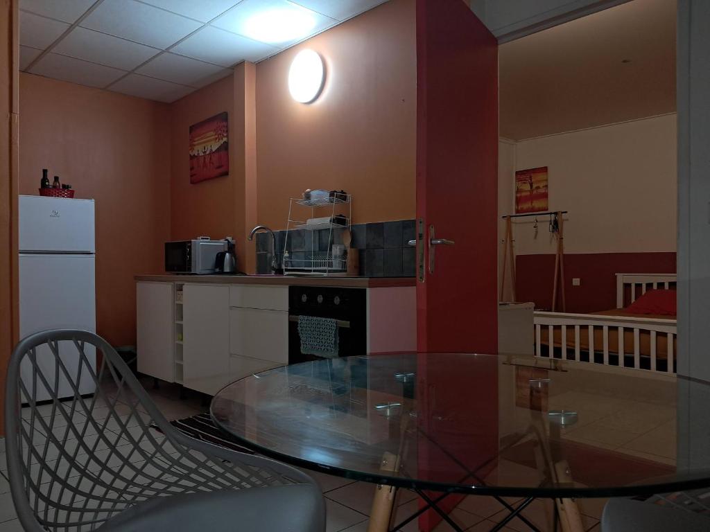 a dining room with a glass table and a kitchen at BlueHorizon180 in Ducos