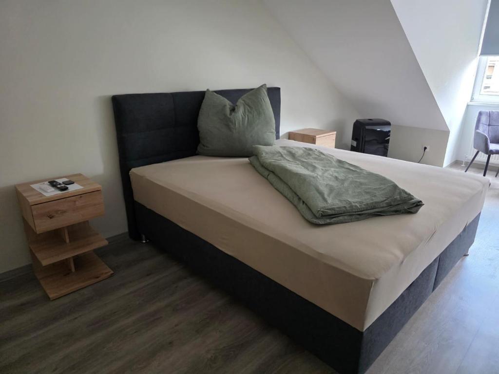 a bed with a black headboard and a night stand at Meisterjäger Akademie in Mellrichstadt