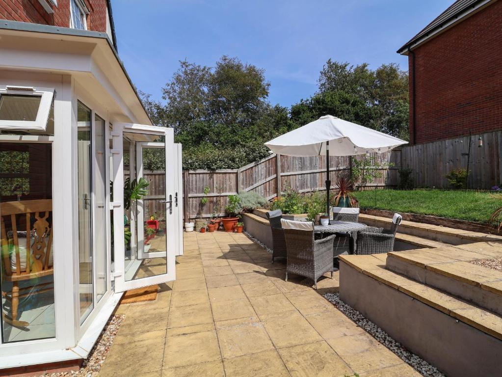 a patio with a table and an umbrella at Manning's View in Barnstaple