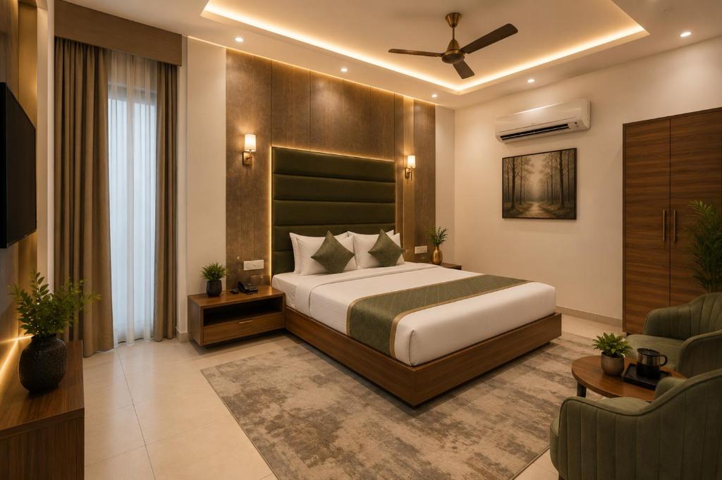 a bedroom with a bed and a couch and a chair at Hotel PG Grand in Mohali