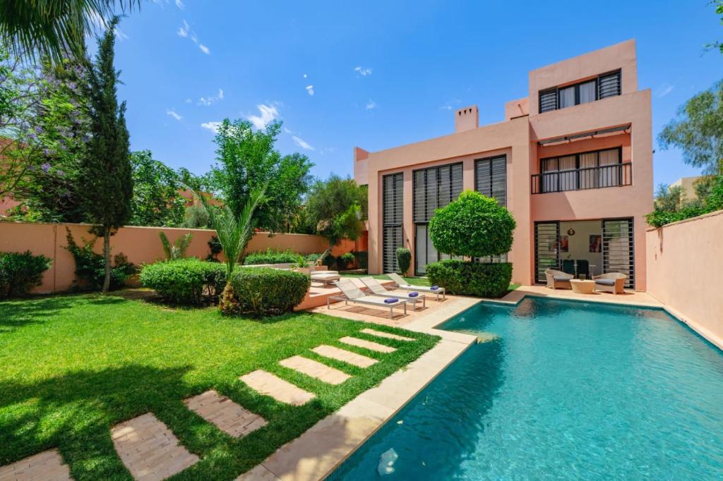 a backyard with a swimming pool and a house at Al Maaden Villa Hotel & Spa in Marrakesh
