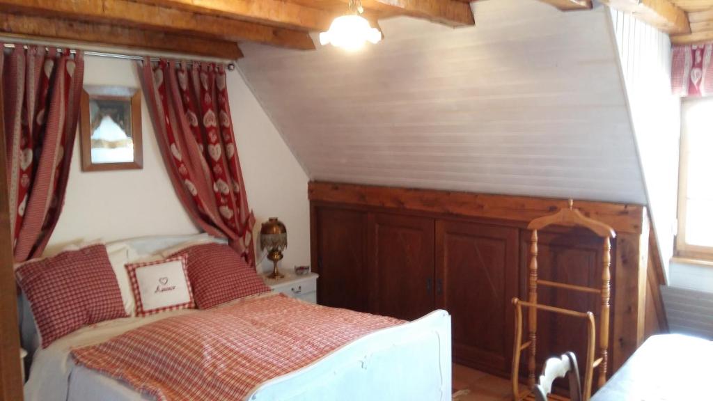 Schlafzimmer mit einem Bett mit roten Vorhängen in der Unterkunft Chambre d'Hôtes "Au Vigneron" in Triembach-au-Val