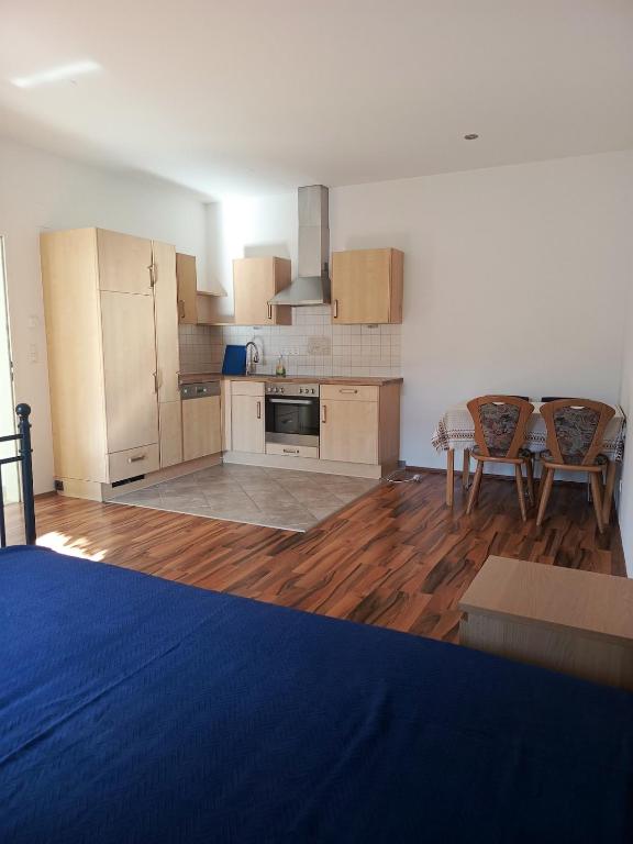 a large kitchen with wooden floors and a table and chairs at Spacious Heritage Apartment for Groups in Bruck an der Leitha