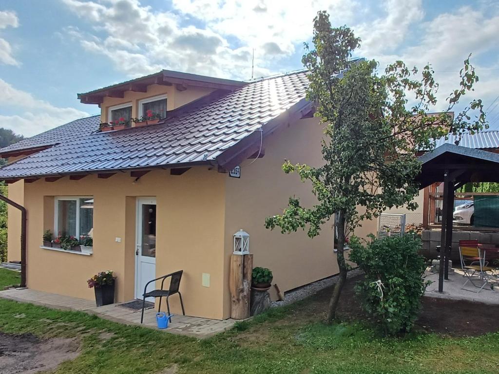 a small yellow house with a black roof at Ubytovanie Málika in Čierny Blh