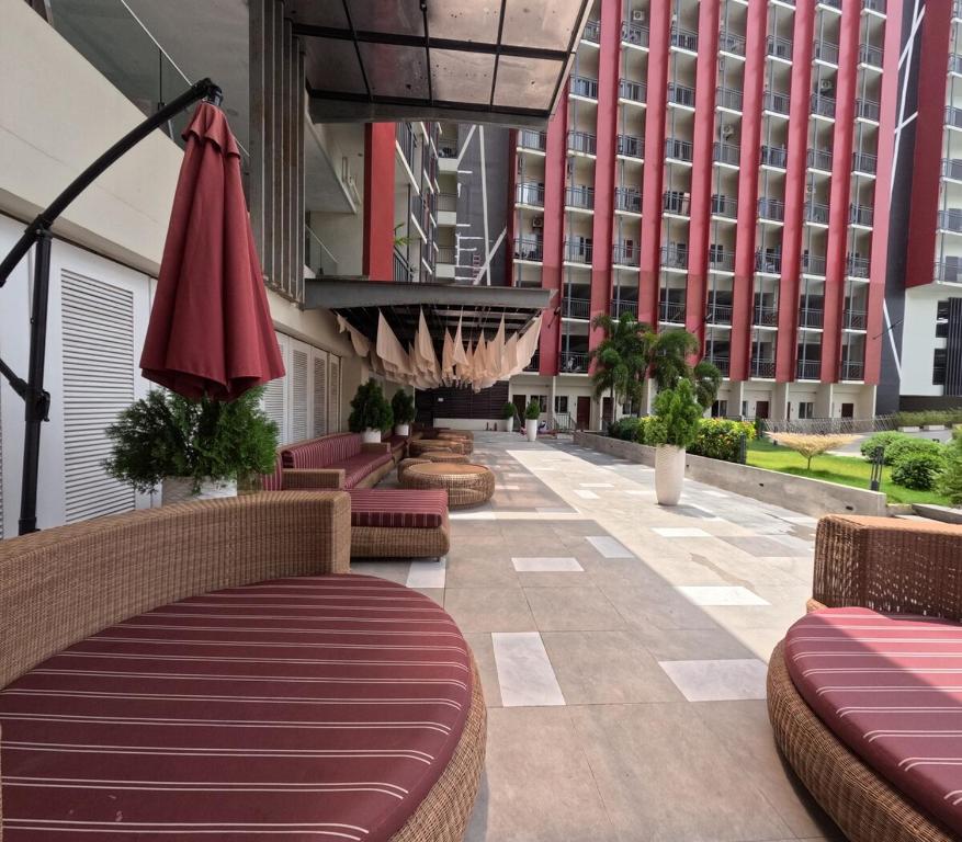 a hotel lobby with benches and a building at Mactan Airport 1BR Resort with Pool in Mactan Island