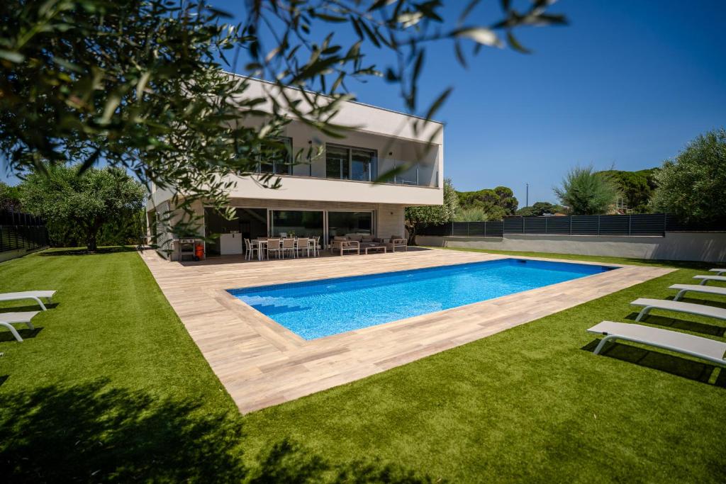 a house with a swimming pool in front of a yard at Modern Villa Olivera with Private Pool in Calella de Palafrugell
